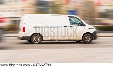 Fast Moving Volkswagen Transporter T6.1 On The City Road. White Minivan Rides On Street. Commercial 