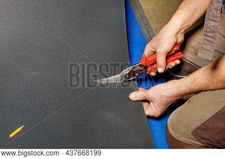 The Male Hands Of A Worker Cut A Sheet Of Roofing Iron With Metal Scissors For Subsequent Waterproof