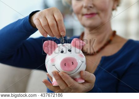 Close-up Of Elderly Woman Putting Coins In Piggybank. Save Pension For Future, Collect Money, Take C