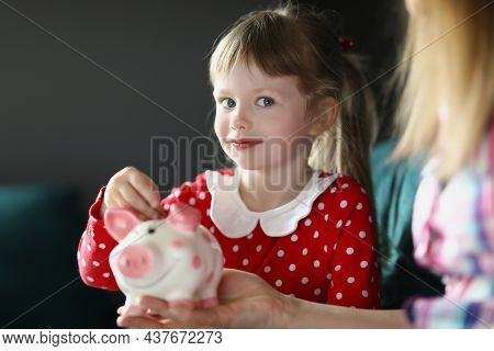 Portrait Of Cute Little Child Putting Coin Into Piggy Bank. Mother Teach Daughter To Save Up, Save T