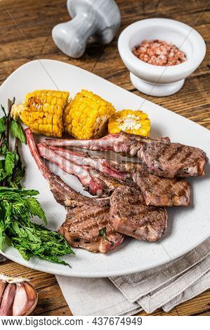 Grilled Lamb Chops Steaks In A Plate With Corn And Tomato. Wooden Background. Top View
