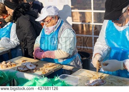 Dieppe, France - November 17, 2019: Men And Women Open And Clean Scallops For Sale At A Fair Of Herr