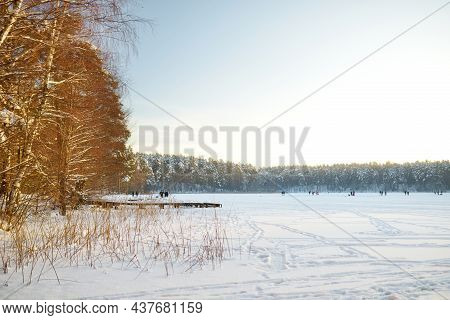 Beautiful View Of Ice Covered Balzis Lake. Snowy Pine Forests Surrounding A Small Lake. Winter Lands