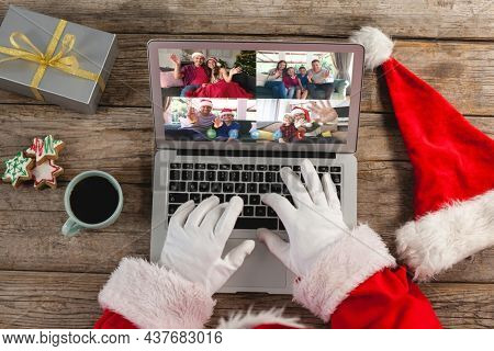Santa claus on christmas laptop video call with diverse group of friends. christmas, festivity and communication technology.