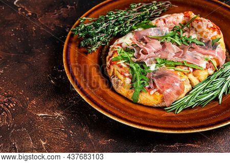 Pizza With Prosciutto Parma Ham, Arugula Salad And Parmesan Cheese In A Rustic Plate. Wooden Backgro