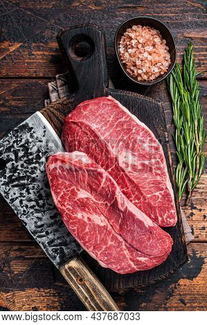 Uncooked Raw Shoulder Top Blade Or Flat Iron Beef Meat Steaks On A Wooden Butcher Board With Meat Cl