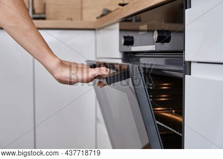Woman Hand Open Electric Oven Door With Handle. Homemade Cooking. Kitchen Appliance