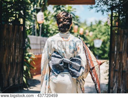 Rear View Of Japanese Woman Wearing Yukata Dress While Walking In Town. A Japanese Yukata Is A Light
