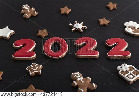 Inscription 2022 From Gingerbread Cookie. Christmas Bacing, Black Background.