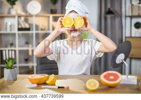 Pretty Female Teenger With Towel On Head And Mask On Face Covering Eyes With Slices Of Oranges. Mine