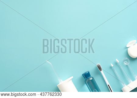 Flat Lay Portable Water Pick Flosser, Toothbrush, Liquid, Flosser On Blue Background. Dental Treatme