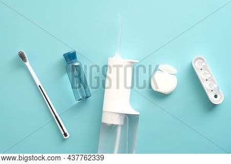 Oral Water Irrigator, Toothbrush, Liquid, Flosser On Blue Background. Flat Lay, Top View, Overhead.