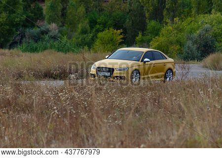 A Sporty Yellow Sedan Drives At High Speed On An Autumn Paved Road. Audi Rs3 Sportback Quattro Car. 