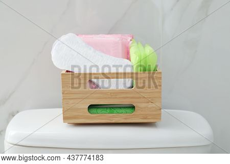 Organizer With Different Feminine Hygiene Products On Toilet Bowl In Bathroom