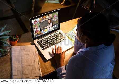 African american woman using laptop for video call, with diverse high school pupils on screen. communication technology and online education, digital composite image.