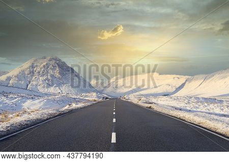 Buachaille Etive Mor Mountain And Empty Road Covered In Snow During Winter