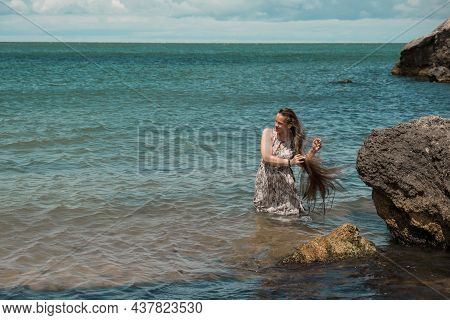 Girl With Long Hair Posing In Water. Treavel By The Sea