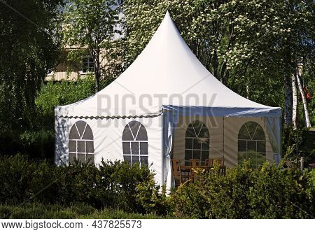 A White Party Tent Spread Out On The Lawn
