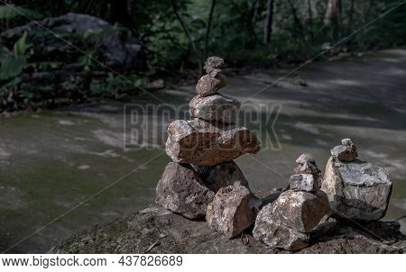 Balanced Stone Tower On Walkway Up The Mountain With Green Plants In The Background. No Focus, Speci