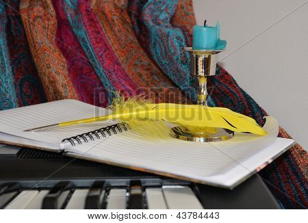 Small Candle In A Candlestick At The Opened Notebook
