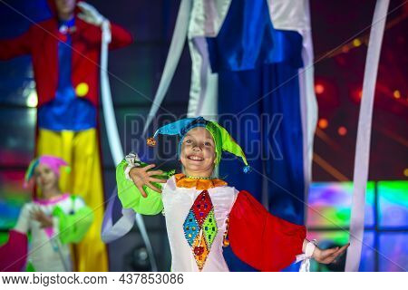 Little Girl Is Dancing In A Clown Costume. The Child Performs On Stage.