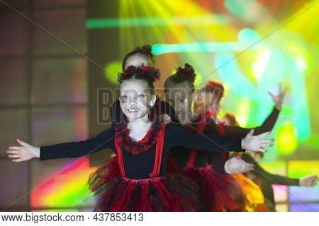 Little Girls Are Performing A Dance Number. Dance For Helovinna In Red Suits. Girl Dancing. Emotiona