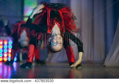 Little Girls Are Performing A Dance Number. Dance For The Hellovinna In Red Costumes. Dancing Little