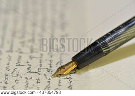 Fountain Pen On A Blurred Letter Background. Old Fountain Pen On An Vintage Handwritten Letter. Conc