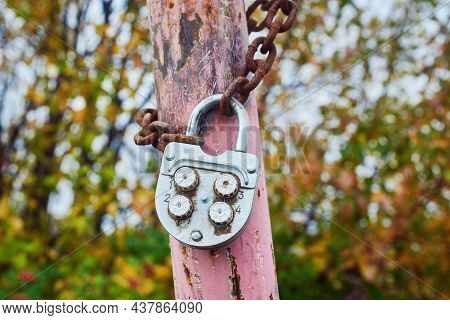 An Old Metal Combination Lock On A Rusty Chain. Close-up, Macro