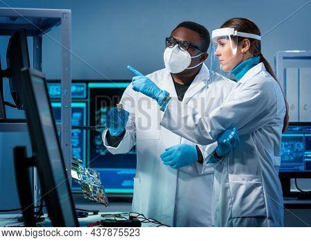 Group Of Microelectronic Engineers Discussing In A Modern Microprocessor Manufacture Lab. Workplace 
