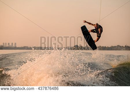 Amazing View Of Active Strong Male Rider Holds Rope And Making Jump On Wakeboard.
