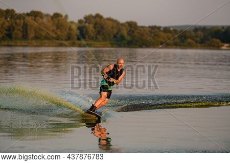 Energy Strong Man Engaged In Water Sport And Balancing On Water Surface On A Wakeboard