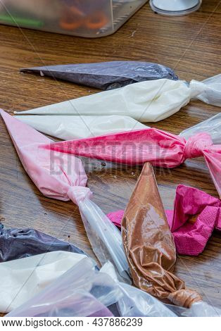 View Of Piping Bags With Couplers And Tips Filled With Royal Icing To Decorate Sugar Cookies. High Q