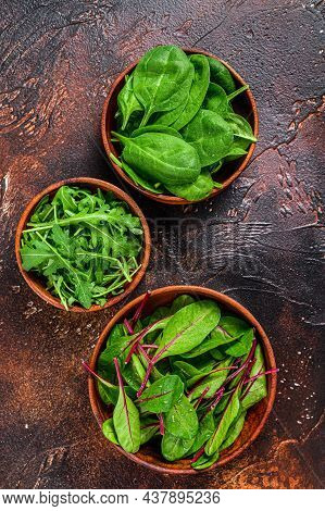 Mix Salad Leafs, Arugula, Spinach And Swiis Chard In Wooden Bowls. Dark Background. Top View