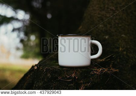 Close-up Mug Mock-up. An Iron Enamelled White Travel Cup With Empty Space For Branding, Standing On 