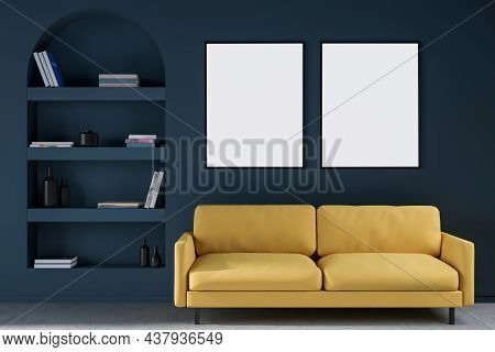 Two Empty Canvases On Wall Over Yellow Two Seater Sofa Near Arch Shelf In Dark Blue Living Room. Mod