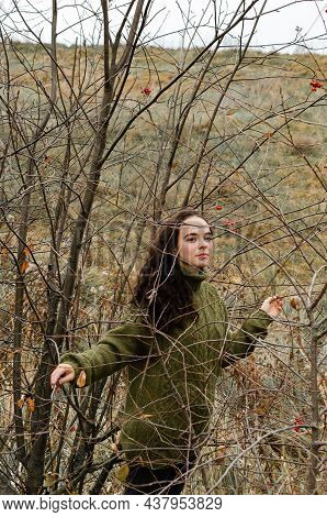 Dreamy Brunette Young Woman Stands In The Forest Surrounded By Tree Brunches. One With Nature Concep