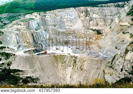Top View Of The Marl Quarry. Heavy Machinery Trucks And Excavators Are Working