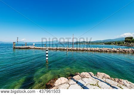 Ferry Boats Station And Entrance Of The Small Port Of Cisano, Tourist Resort On The Coast Of Lake Ga