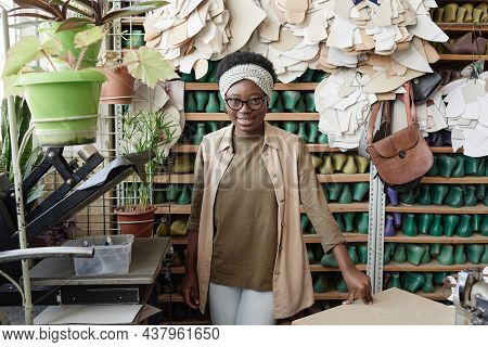 Portrait Of African Young Shoemaker Smiling At Camera While Standing In The Workshop With Shoelast O