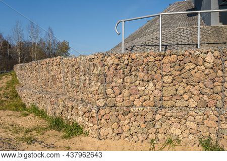 Engineering Structure Made Of Stones Behind Metal Wire Netting To Strengthen The River Bank Near The