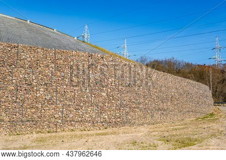 Engineering Structure Made Of Stones Behind Metal Wire Netting To Strengthen The River Bank Near The