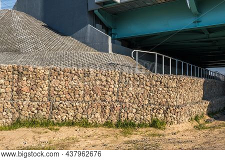 Engineering Structure Made Of Stones Behind Metal Wire Netting To Strengthen The River Bank Near The