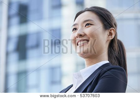 Low angle view of young businesswoman smiling