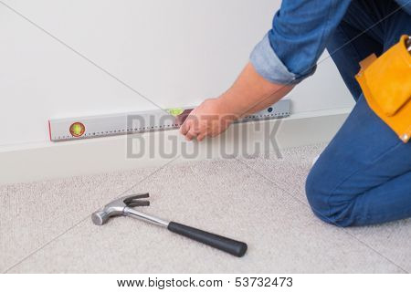 Close up mid section of a handyman using a spirit level