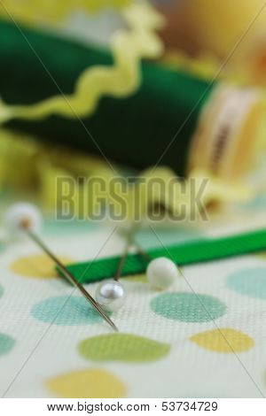 Needles pins with ribbons and thread on a polka dots material