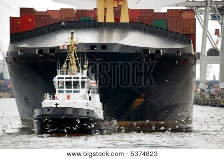 Slæbebåd trækkende fragtskib i havnen