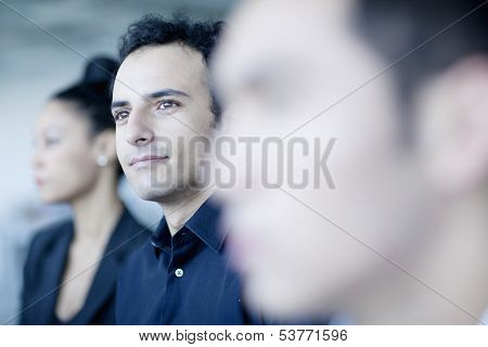 Young businessman sitting in business meeting with colleagues
