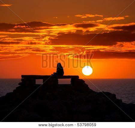 Ciutadella Menorca at Punta Nati orange sunset with girl backlight