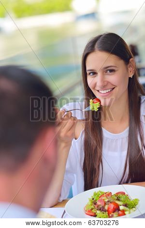 happy young couple having lanch at beautiful restaurant on by the sea on  beach